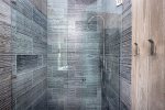 The walk-in shower features custom tile and high end fixtures.